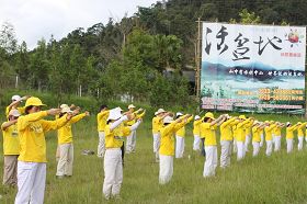 靠近日月潭入口的鱼池乡长红茶休闲广场旁，近百位法轮功学员演示功法。