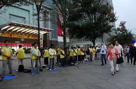 台湾法轮功学员长期在台湾各景点讲真相及洪法，图为大陆观光客观看法轮功学员在台北一零一大楼前炼功。