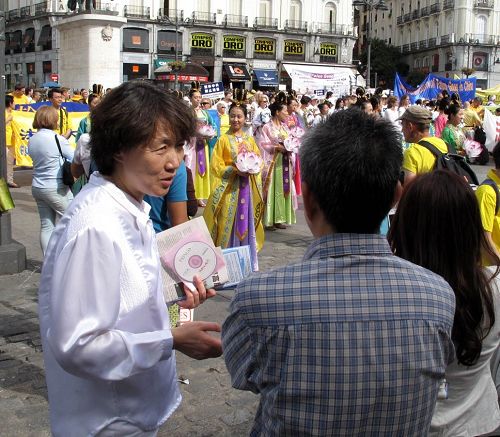 图5-6：在太阳门广场法轮功反迫害集会现场，法轮功学员向驻足观看的华人讲真相劝三退