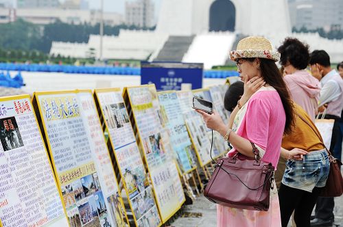 图5-7：一旁的“正法之路图片展”与“真相展板”让民众在观赏排字之余，也有机会深入了解世界各地法轮功学员多年来洪法、讲真相的历程