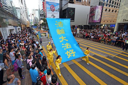 图1-2：香港法轮功学员于二零一五年七月十八日，游行从九龙区旺角、佐敦，再到尖沙咀广东道，抵达终点天星码头。沿途吸引港民及中西旅客观看。