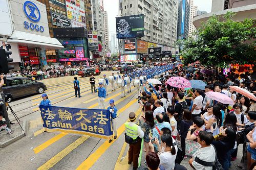 图3-4：香港法轮功学员于二零一五年七月十九日，游行从港岛区英皇道、轩尼诗道，途经闹市铜锣湾、湾仔、中环，最终到西环中联办，历时约四小时，沿途吸引港民及中西旅客观看。