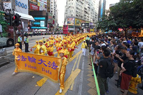 图8-11：一千多名法轮功学员的游行队伍吸引游客驻足聚焦并拍照。