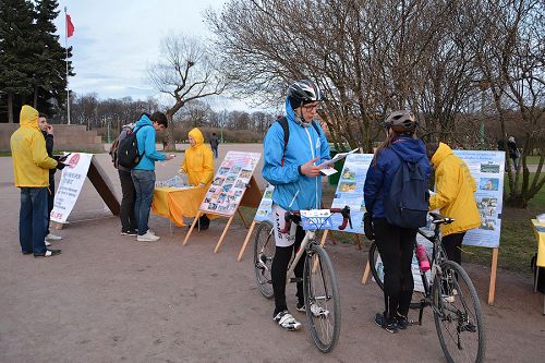 图3-5：许多民众经过时，有的驻足阅读真相展板、真相资料，有的与学员交谈了解迫害真相。