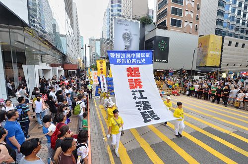 图15-20：法轮功学员希望民众了解真相，在游行队伍中打出了揭迫害、唤良知、启善念、劝三退，及全球控告迫害元凶江泽民等横幅。