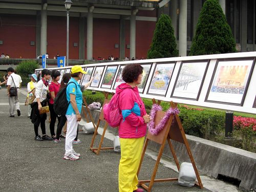 图6-10：法轮功正法之路图片展吸引游客驻足观看。