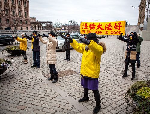 '图1，瑞典法轮功学员在钱币广场上举办法轮大法信息日活动'