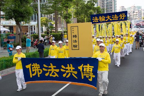 '图3：二零一七年高雄法轮功学员集会游行，提前“庆祝世界法轮大法日”，展开指导修炼的《转法轮》巨型模型。'