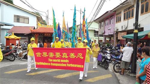 '图1～5：二零一八年五月二十日，部份法轮功学员来到邦咯岛举行游行，与民欢庆世界法轮大法日，所到之处普遍获得当地民众的欢迎。'