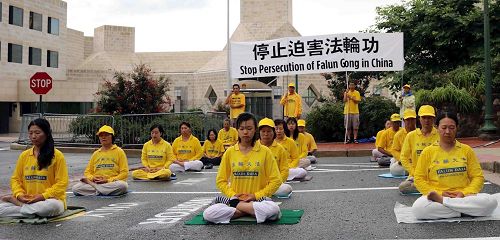 '图2：二零一八年七月二十二日傍晚，美国华府地区部份法轮功学员冒着风雨在中共驻美国大使馆前炼功，呼吁停止迫害法轮功。'