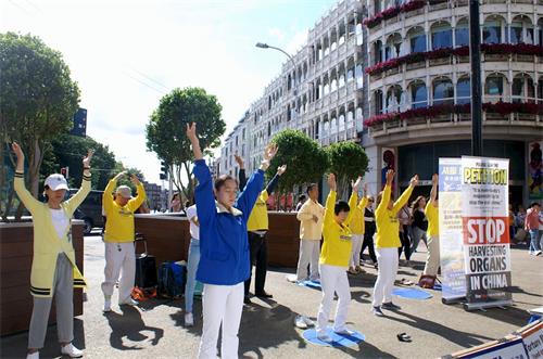 '图1～2：二零一八年八月十八日，?爱尔兰部份法轮功学员聚集在都柏林市中心的格拉夫顿大街集体炼功，传播大法的美好，揭露中共残酷迫害法轮功的恶行。'