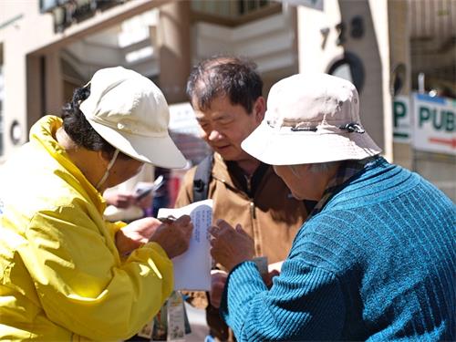 图5：法轮功学员正在忙着帮助三退的民众起化名三退