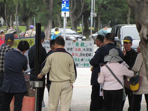 '图2：中国大陆游客观看法轮功真相展板，聆听学员讲真相。'