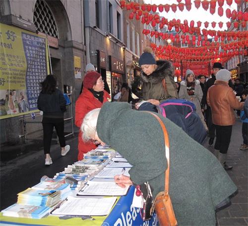 '图11：二零一九年二月十日，来自位于西班牙和法国之间的巴斯克自治区（Basque Country autonomous community）的埃斯特尔（Estelle）女士（左一）在伦敦唐人街签名支持法轮功反迫害'