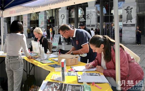 '图4：十月二日，在康士坦茨（Konstanz）的奥古斯缇纳（Augustinerplatz）广场上，了解真相后的路人签名支持制止中共活摘罪行。'