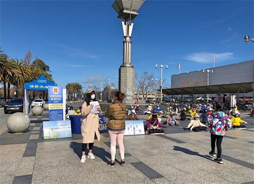 '图1～2：二零二一年三月六日，旧金山部份法轮功学员来到渡轮大厦前的广场集体炼功，告诉人们“法轮大法好，真善忍好”。'