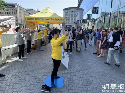 图1： 法轮功学员在布鲁塞尔中心商业区举办活动揭露中共持续二十二年的迫害真相