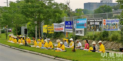 '图1～2：2021年7月20日，法轮功学员反迫害22周年之际，加拿大首都渥太华部份法轮功学员汇聚到中使馆前，要求中共立即停止迫害，并释放所有被非法关押的法轮功学员。'