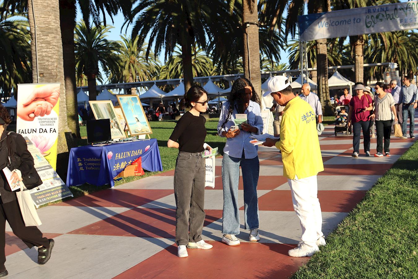 '图1~4:二零二五年十月十一日,第24届尔湾地球村节在大公园盛大举办。法轮大法修炼者在草坪上布置了“真善忍美展”,并向居民展示五套功法。'