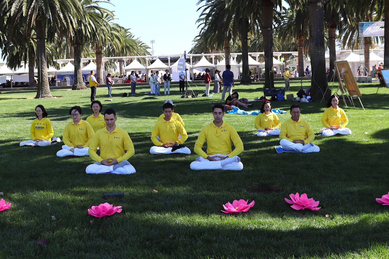 '图5~7:二零二五年十月十一日, 第24届尔湾地球村节,法轮功学员在舞台上和大公园的草坪展示五套功法。'