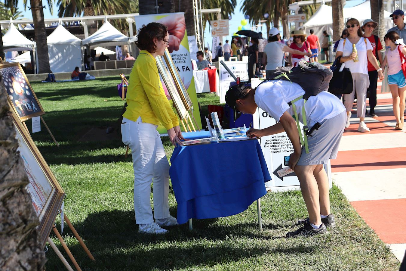 '图8~10:二零二五年十月十一日, 第24届尔湾地球村节,法轮功学员传递法轮大法的美好真相,揭露中共活摘法轮功学员器官和征集反迫害的签名。'