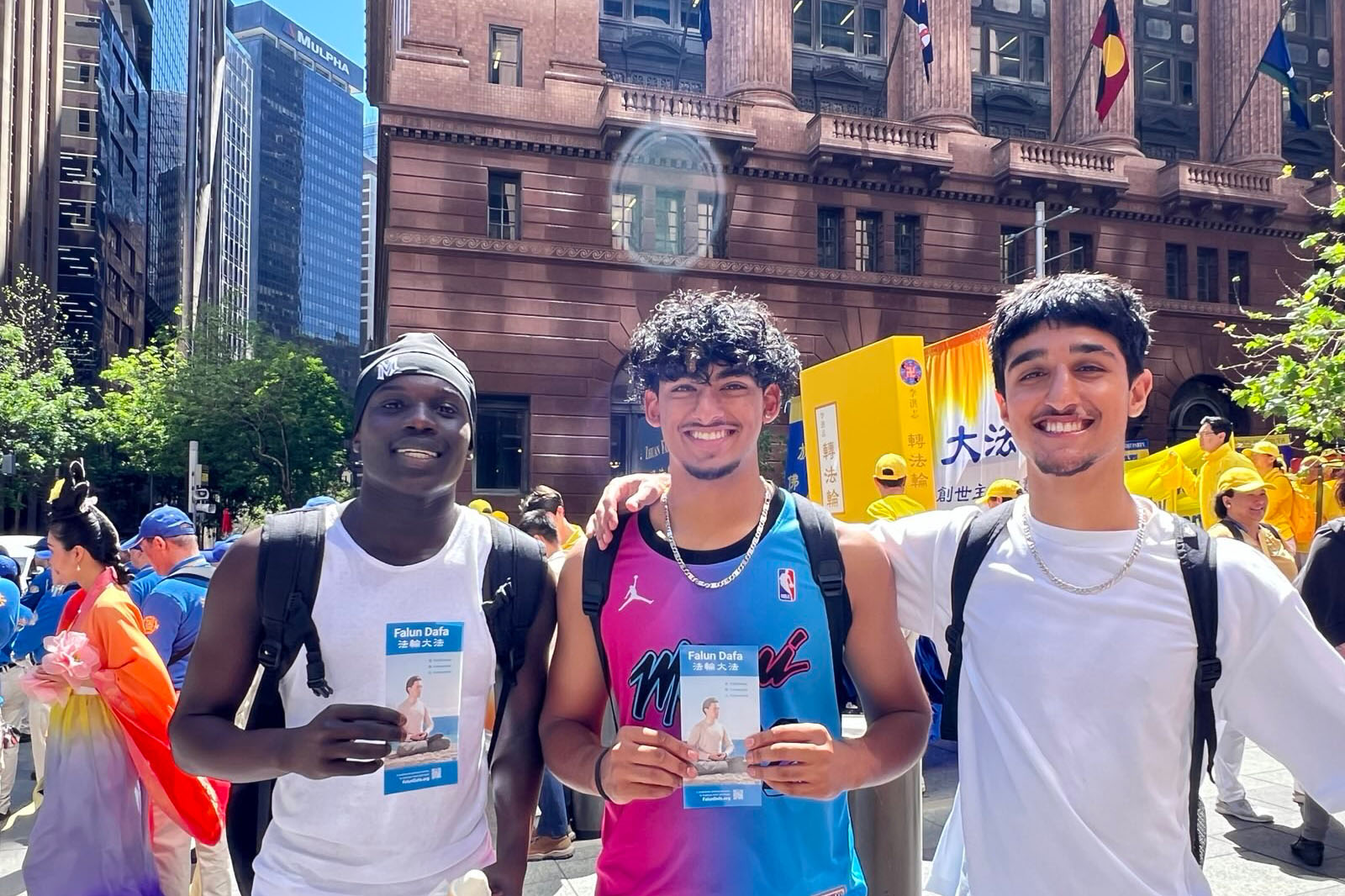 图12:十月十一日,学生塔维安·利马(中)和穆罕默德·阿卜杜勒·阿齐兹(右)与同伴在悉尼市中心法轮功学员游行现场合影。